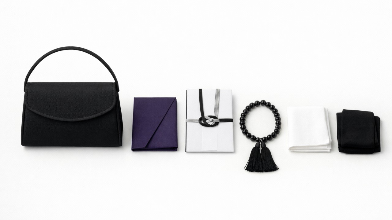 黒いバッグ、袱紗、香典袋、数珠、白いハンカチ、黒ストッキングを整然と並べた日本の弔事準備イメージ