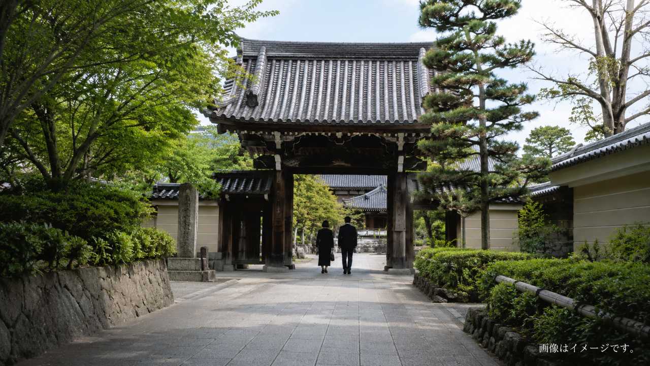 大阪の落ち着いた寺院の山門と参道を背景に、納骨や供養をイメージできる穏やかな雰囲気の実写風ブログ用アイキャッチ画像